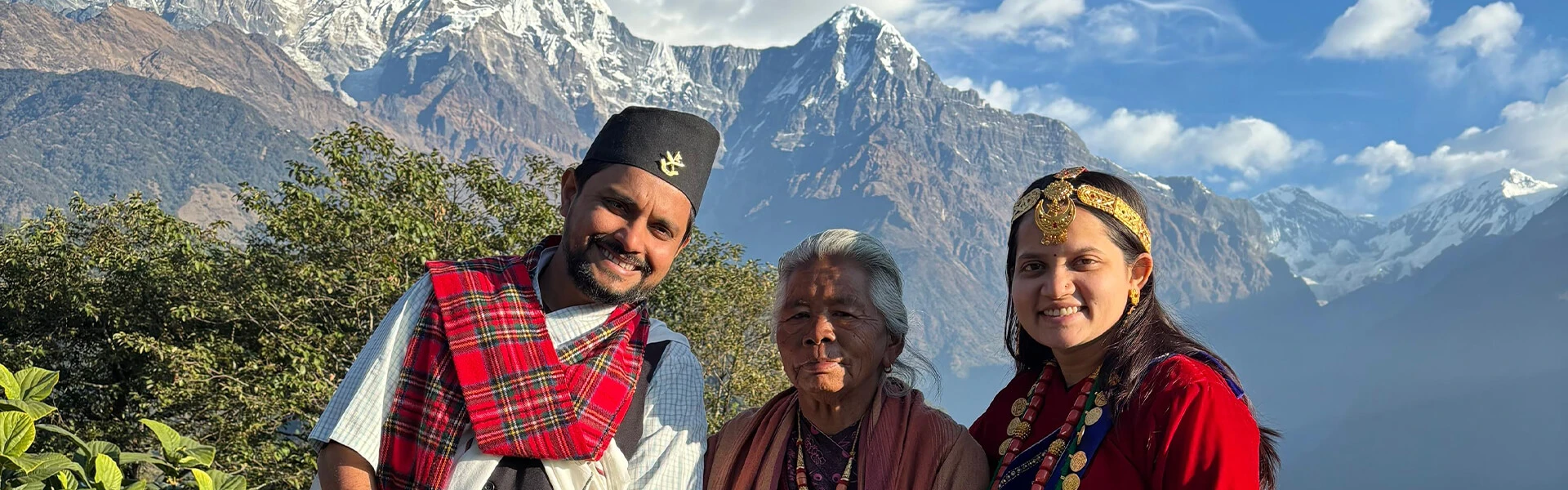 A family photo in traditional attire with mountains in the background
