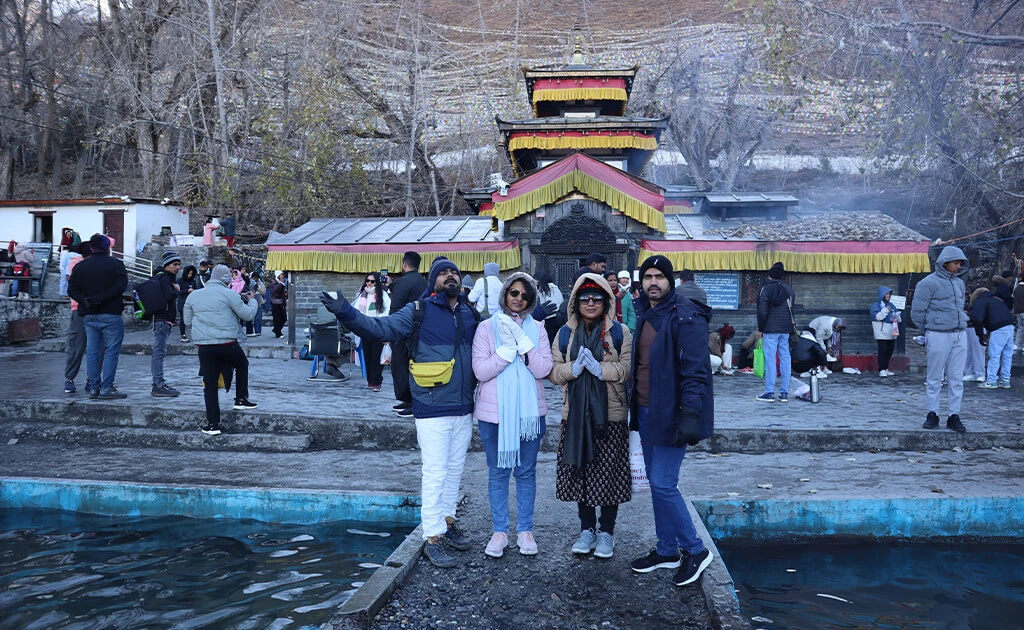 Visitors standing near Muktinath Temple during their pilgrimage