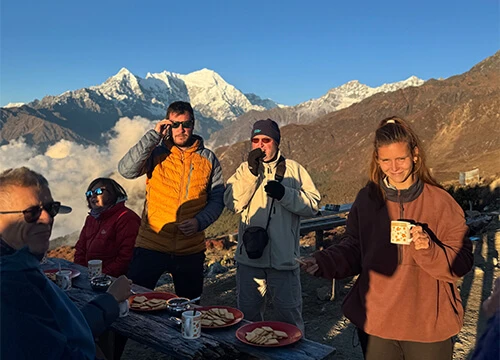 Trekkers enjoying breakfast with sunrise views of the Langtang Himalayan range