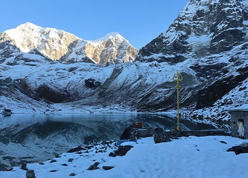 Snowy peaks, lake, and shrine
