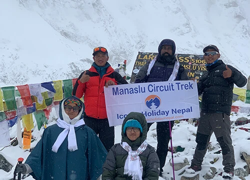Trekkers holding a banner at Larkya La Pass